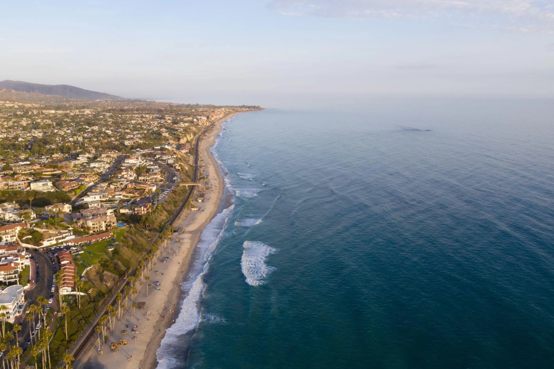 A coastal road follows the shoreline above the Pacific